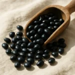 자연광 아래에 놓인 윤기 나는 검은콩들의 모습입니다.