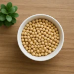 원목 테이블 위에 노란 콩이 담긴 하얀 그릇과 작은 식물이 평온한 느낌을 줍니다.