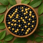 나무 그릇에 담긴 신선한 검은콩과 대두가 푸른 잎사귀와 함께 놓인 모습입니다.