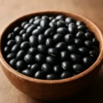 나무 그릇에 담긴 윤기 나는 검은콩들의 클로즈업 사진입니다.
