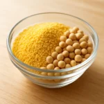 유리 볼에 담긴 신선한 대두와 노란색 레시틴 과립이 놓여 있는 깨끗하고 밝은 분위기의 사진입니다.