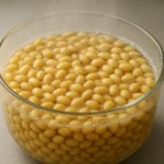 냄비 안에서 맑은 물과 함께 끓고 있는 영양가 높은 콩들의 모습입니다.