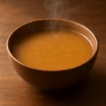 소화에 부담을 주지 않는 부드럽고 따뜻한 콩국이 정갈하게 담겨 있는 모습입니다.